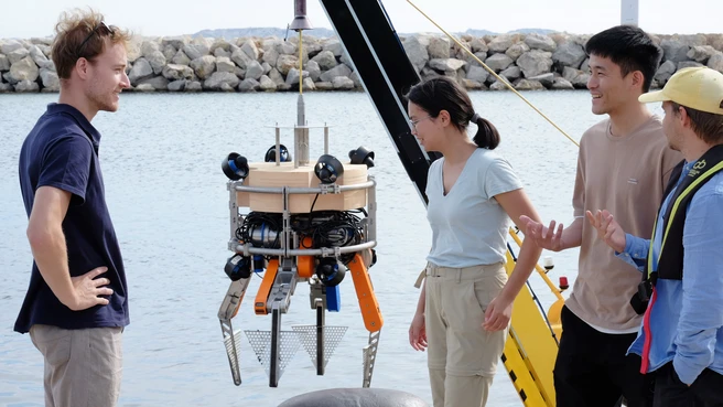 Researchers Nicolas Hoischen, Zara Zothabayeva, Tau-Yuan Huang, and Hanisch Grant (from left to right) from the Technical University of Munich in front of the diving robot. 