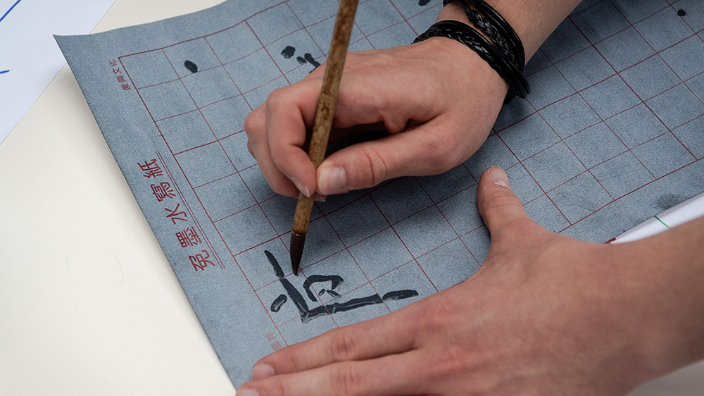 Hände beim Kalligraphieren mit Griffel