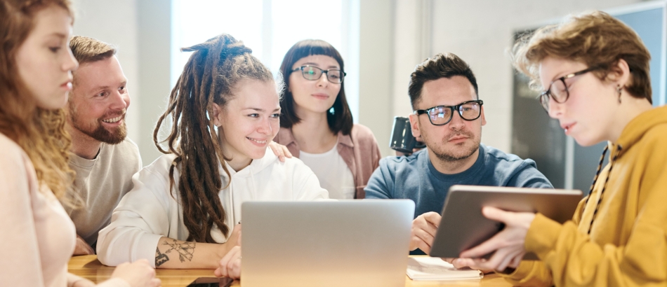 Studierende arbeiten zusammen am Rechner und Tablet